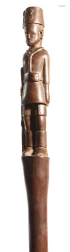 An East African carved hardwood walking stick, the handle carved as an Askari soldier, early 20th