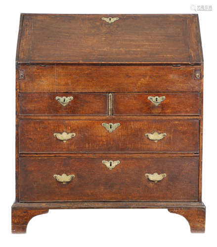 A George II oak bureau, the hinged fall revealing pigeonholes and drawers, with a central cupboard