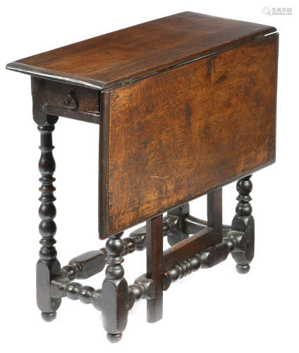 An early 18th century oak gateleg table, the single drop-leaf top on baluster ring and bobbin turned