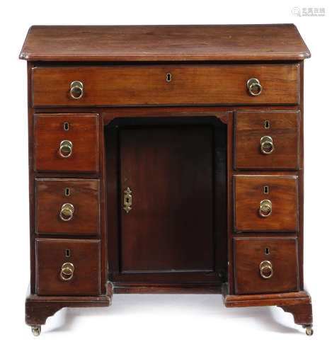 A George II mahogany kneehole desk, the top with a caddy moulded edge, with re-entrant front