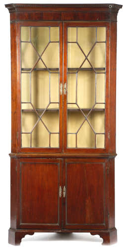 A George III mahogany standing corner cupboard, the dentil cornice above a pair of astragal glazed