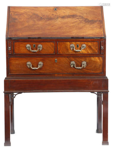 A George III mahogany bureau on stand, the hinged fall revealing an interior with cedar lined