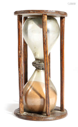 An early 18th century ash sandglass, with four stick supports, the double hourglass bulbs