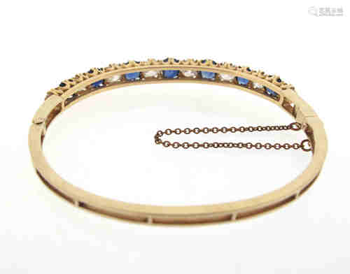 A Victorian sapphire and diamond bangle, alternately set with cushion-shaped sapphires and