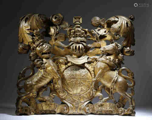 An early Georgian carved giltwood Royal Coat of Arms, carved with scrolling leaves, an English
