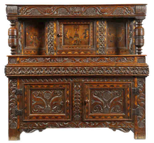A Welsh oak and marquetry press cupboard, inlaid with parquetry banding, the frieze naively carved