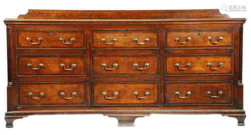 A George III Lancashire oak chest, mahogany crossbanded, the shaped raised back above a moulded edge