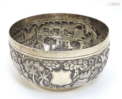 A white metal bowl decorated with buildings, trees birds, and a steam train with carriages.