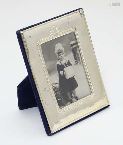 An easel back photograph frame with silver surround.