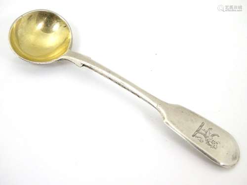 A Victorian silver fiddle pattern salt spoon with gilded bowl and engraved armorial to handle.