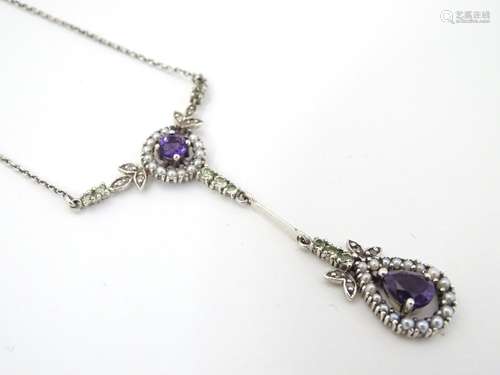 A silver necklace set with amethyst, peridot and seed pearls.