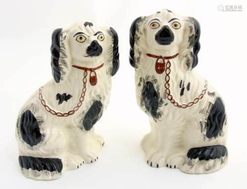 Two Victorian Staffordshire spaniels, with black patch decoration and brown lock and chain,