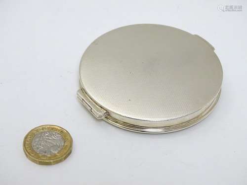 A silver compact of circular form with engine turned decoration hallmarked Birmingham 1965 maker