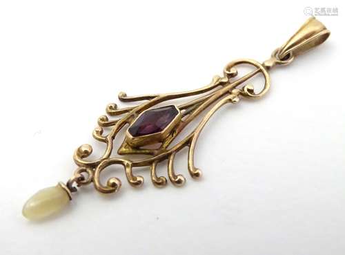 A 10k gold pendant set with purple paste stone and mother of pearl drop.