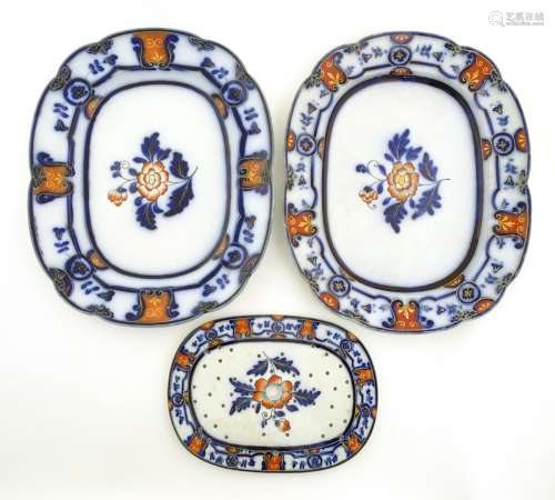 Two oval meat plates and a matching oval drainer decorated with an Imari style design,