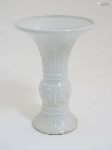 A Chinese white glazed Gu vase of archaic bronze design,