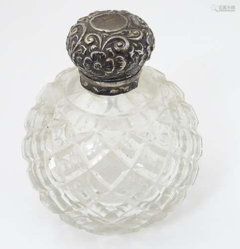 A cut glass scent bottle and stopper with silver top.