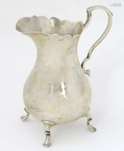 A silver jug on four feet.