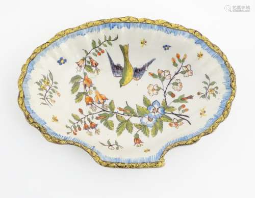 A dish in the form of a shell, decorated with flowers and a bird. Indistinct maker's mark to base.