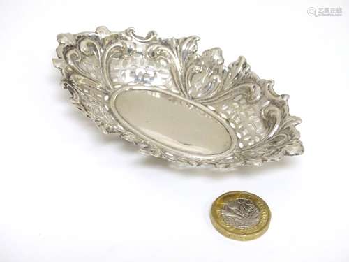 A silver bon bon dish with embossed floral and C-scroll decoration.