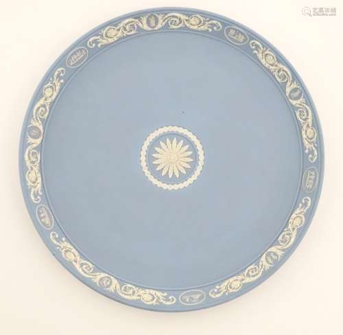 A Wedgwood light blue Jasperware charger with a flower to the centre and with a border of classical