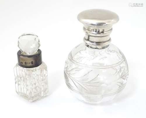 A cut glass scent bottle with silver top hallmarked 1918 together with another with silver collar