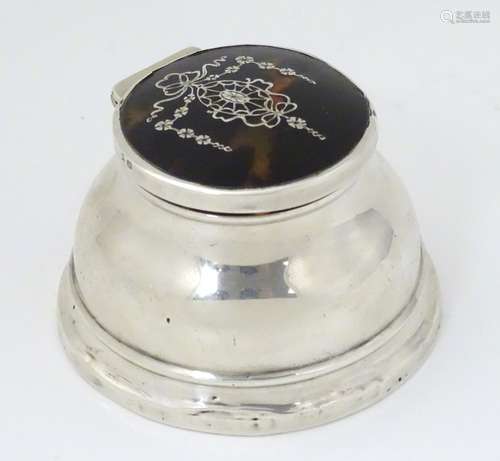 A silver inkwell having tortoiseshell to lid with inlaid piquet decoration.