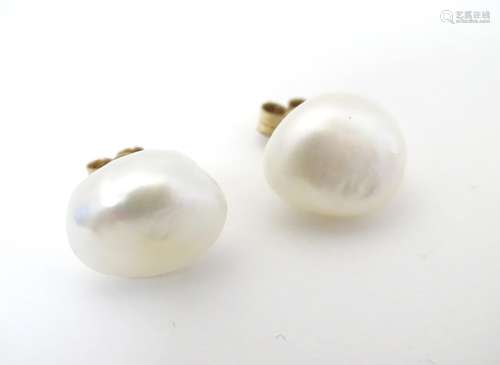 A pair of 9ct gold blister pearl stud earrings. The pearls approx 1/2