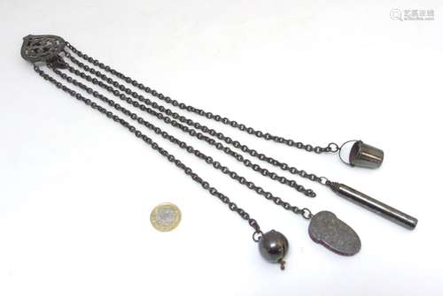 A 19thC cut steel 5- chain chatelaine with acorn shaped pin holder, tape measure,