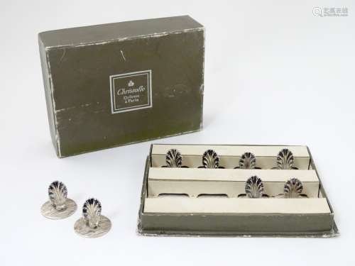 A cased set of 8 silver plate table place card / menu holders with shell decoration.
