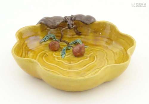 A Chinese wavy edged yellow brush wash dish with bat and fruit decoration,