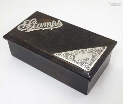 An ebonised wooden stamp box with silver mounts to the hinged lid,