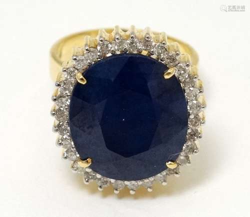 A 14ct gold ring set with sapphire bordered by diamonds.