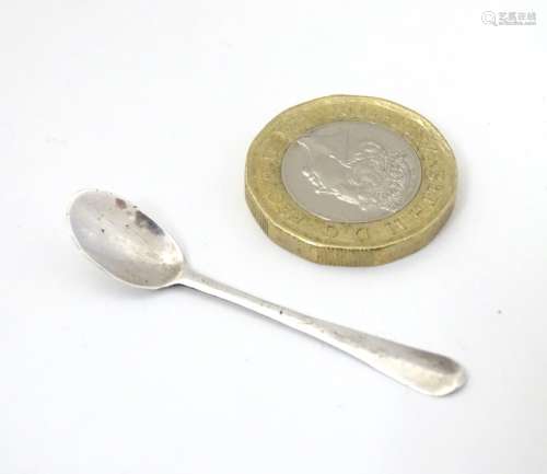 A white metal miniature spoon, possibly a snuff / cayenne spoon or a dolls house spoon.