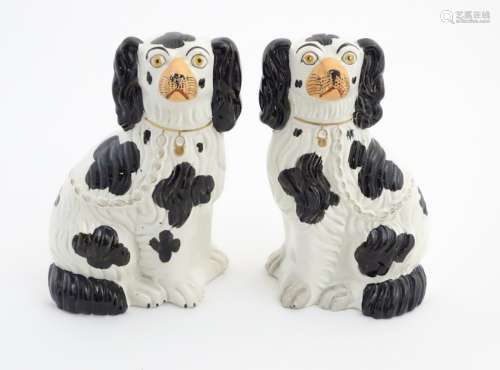 Two Victorian Staffordshire seated spaniels with black patch decoration and gilt lock and chain