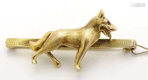 A vintage 9ct gold bar brooch set with model of an Alsatian type dog to centre with ruby eyes .