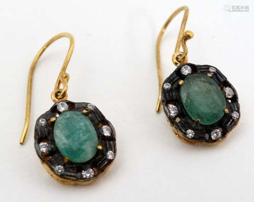 A pair of yellow metal drop earrings set with green and white stones .