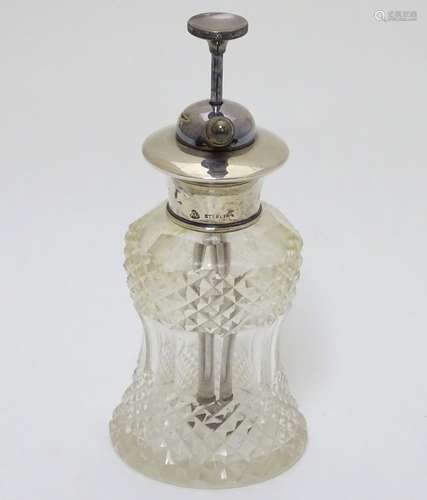 A cut glass scent / perfume bottle with silver atomizer top.