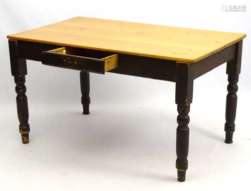 A late 19thC kitchen table with stripped pine top and painted base,