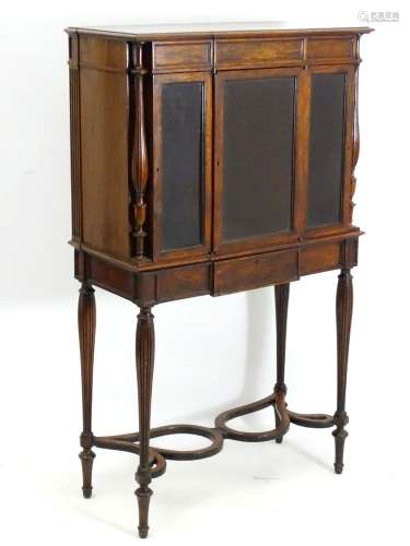 A mid 19thC rosewood collectors cabinet with three glazed doors flanked by turned reeded baluster