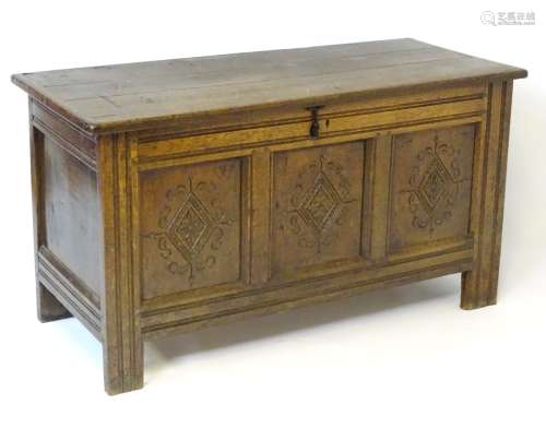 A 17thC oak coffer opening to reveal original hinges, candle box and storage space within,