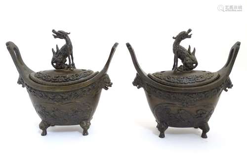 A pair of Chinese boat shaped 4 - legged censors surmounted by mythical beasts and having patterned