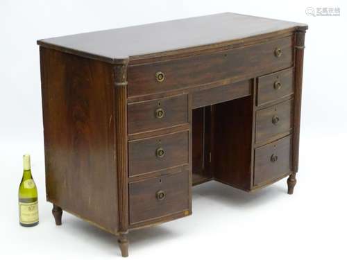 A late 19thC mahogany kneehole desk with castellated front edge above Corinthian columns with