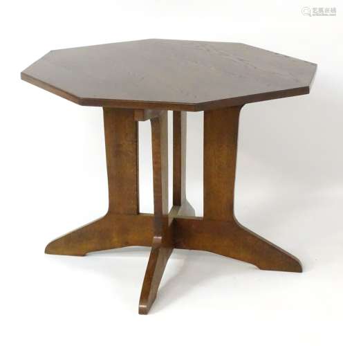 A mid 20thC oak occasional table in the Arts and Crafts style with an octagonal table top above an