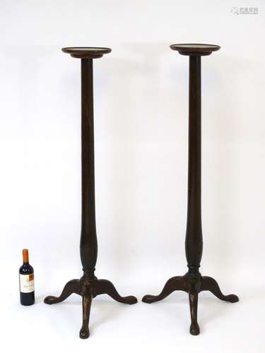 A pair of Victorian mahogany torcheres with dished tops and turned tapering stem,