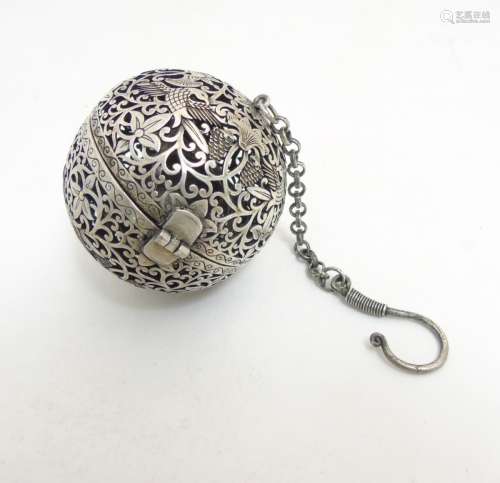 A Chinese white metal censor ball with pierced decoration of birds etc 2 1/4