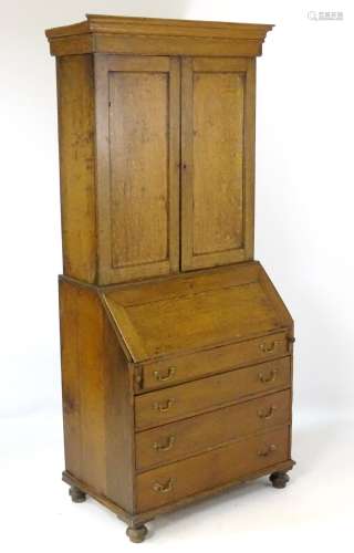 A late 18thC / early 19thC oak bureau bookcase with moulded cornice above two panelled doors