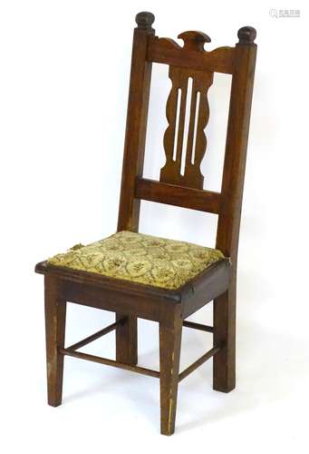 An early 20thC childs chair with pierced back splat above a squared upholstered seat,