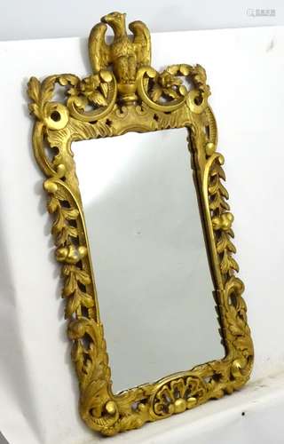 A late 18thC / early 19thC giltwood mirror surmounted by an eagle with floral carving throughout