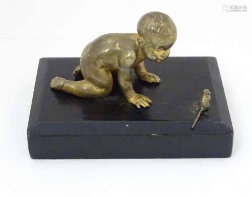 A mid - late 20thC gilded bronze small sculpture of a baby and a mouse, on ebonised base.